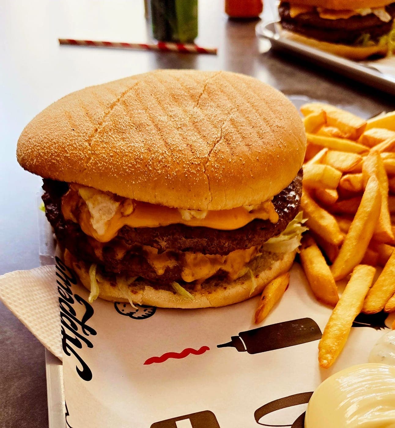 Burger double steak au cheddar, servi avec des frites